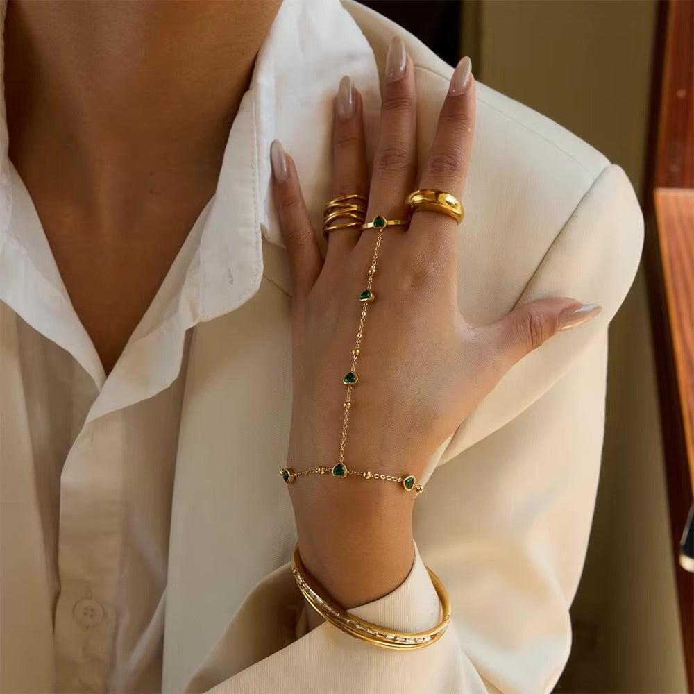 Gold hand chain with emerald hearts