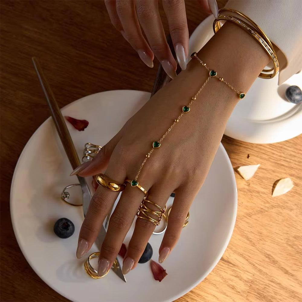 Gold hand chain with emerald hearts