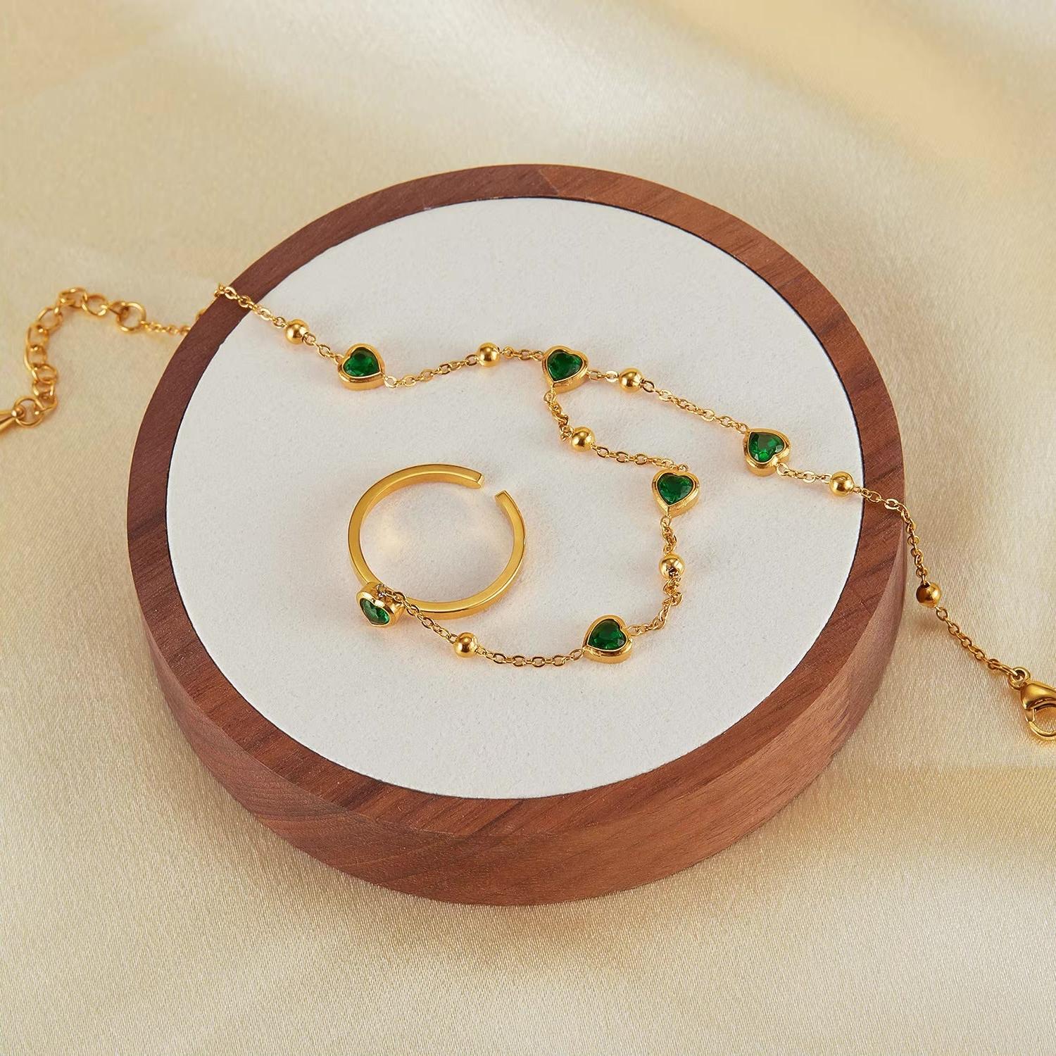 Gold hand chain with emerald hearts