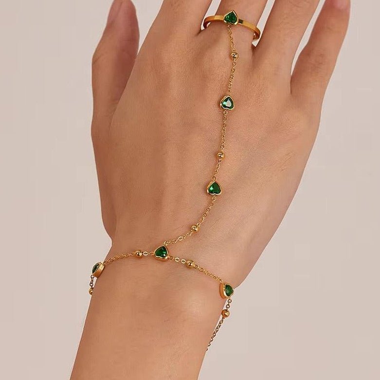 Gold hand chain with emerald hearts