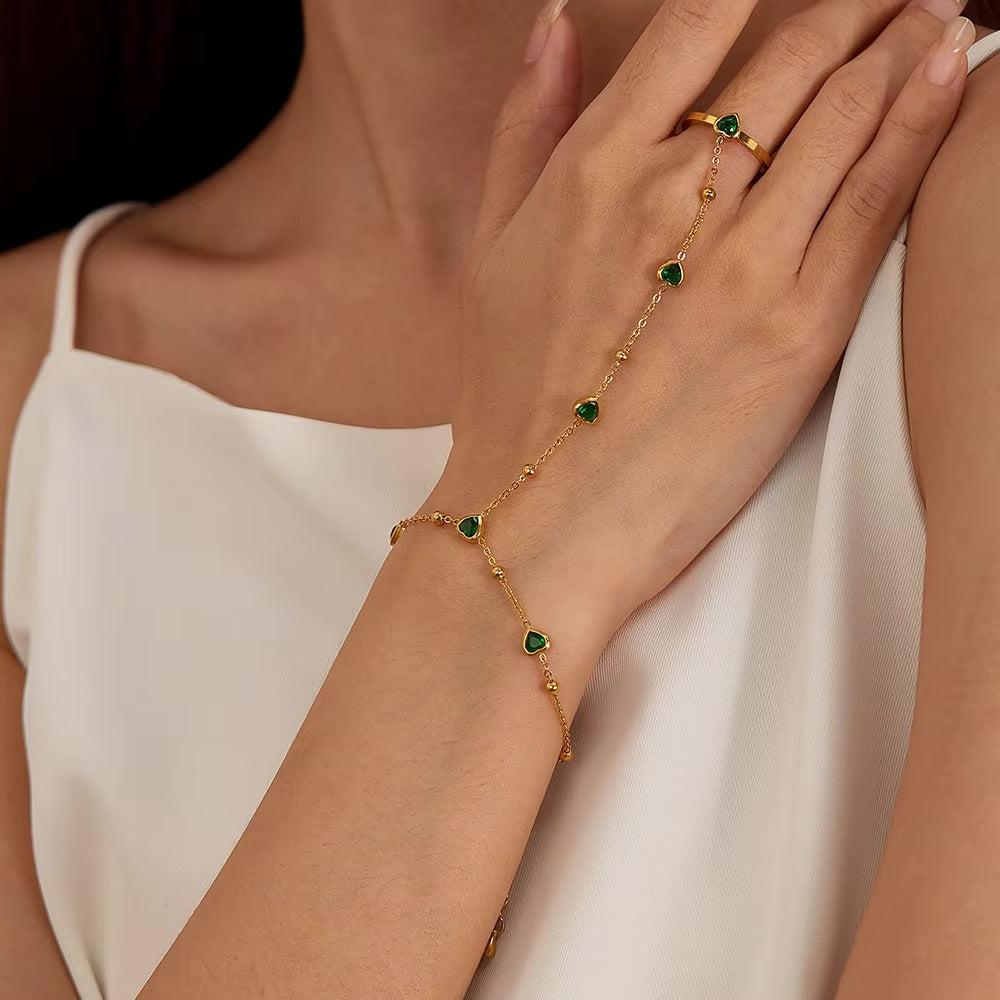 Gold hand chain with emerald hearts