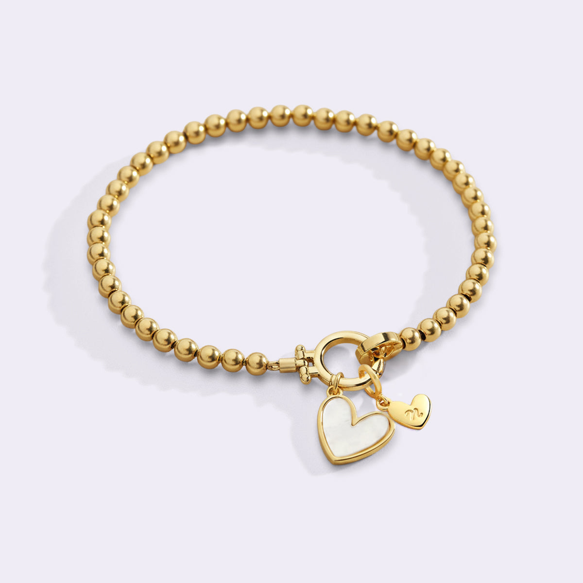 Armbånd med hjerteformet perlemor-initial og hjerteformet charme