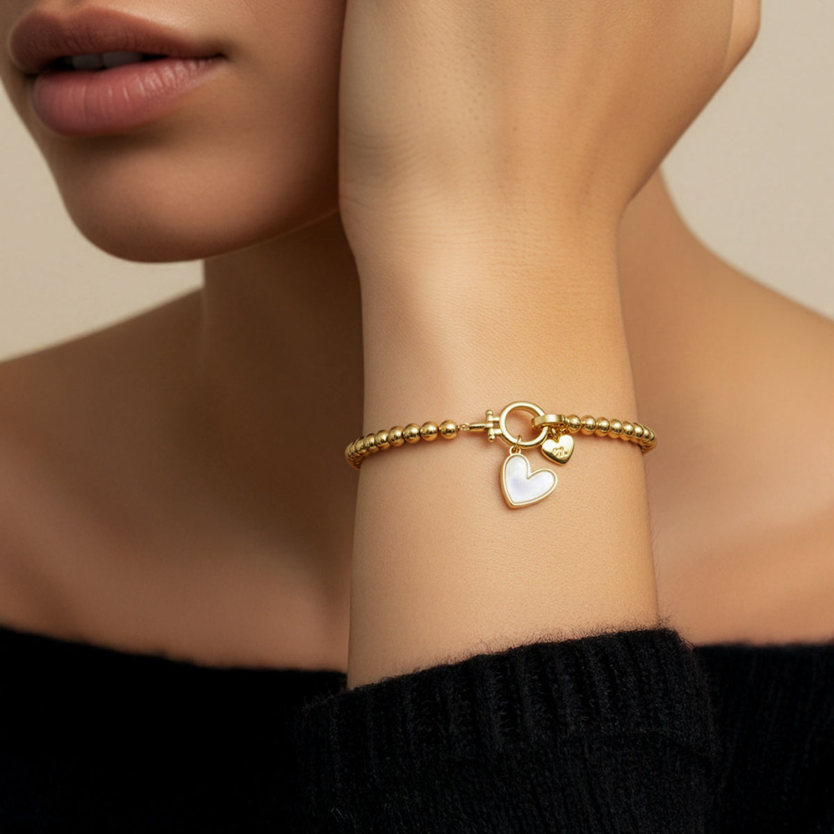 Armbånd med hjerteformet perlemor-initial og hjerteformet charme