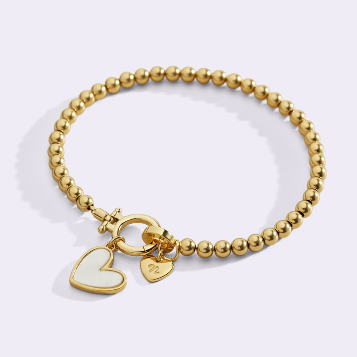 Armbånd med hjerteformet perlemor-initial og hjerteformet charme