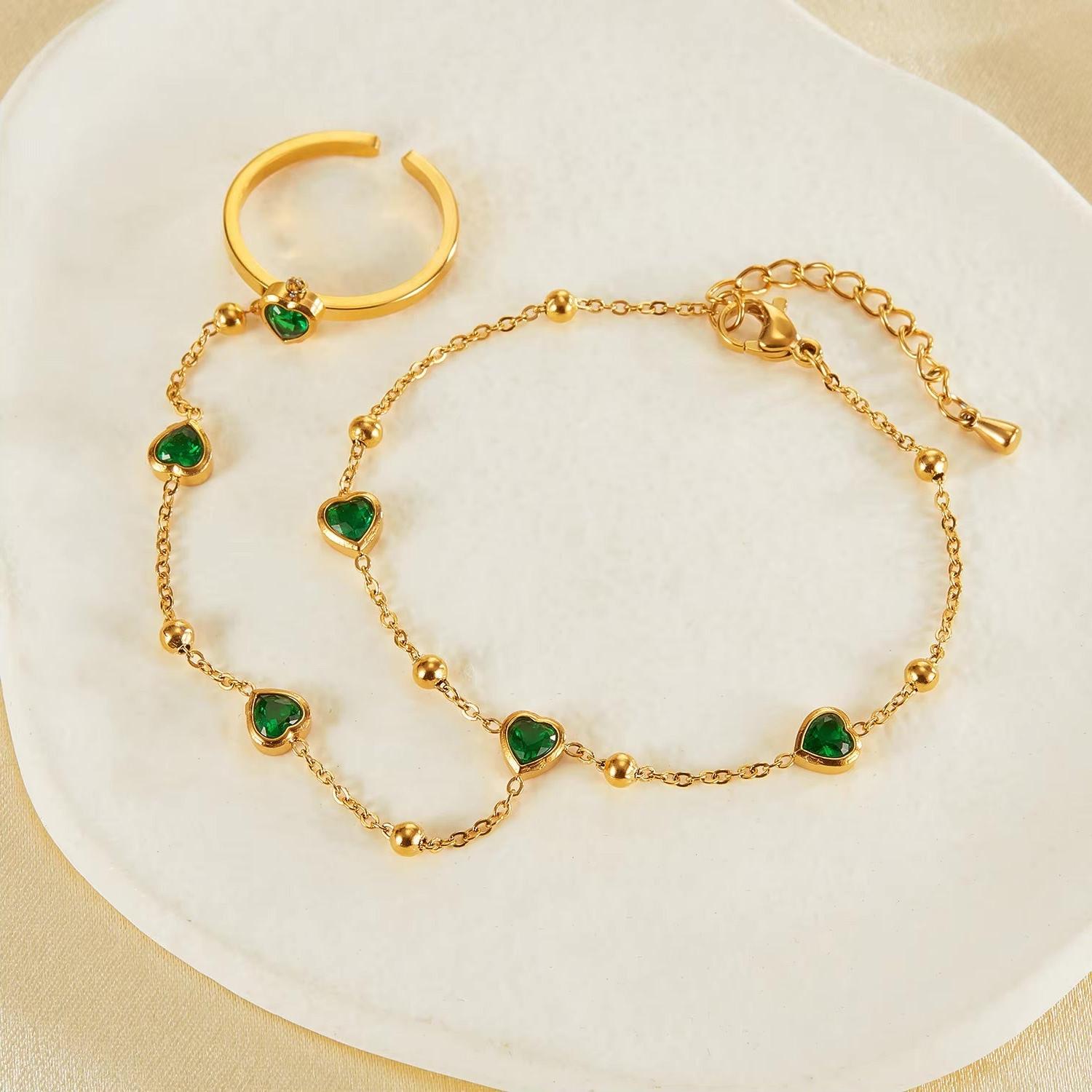 Gold hand chain with emerald hearts